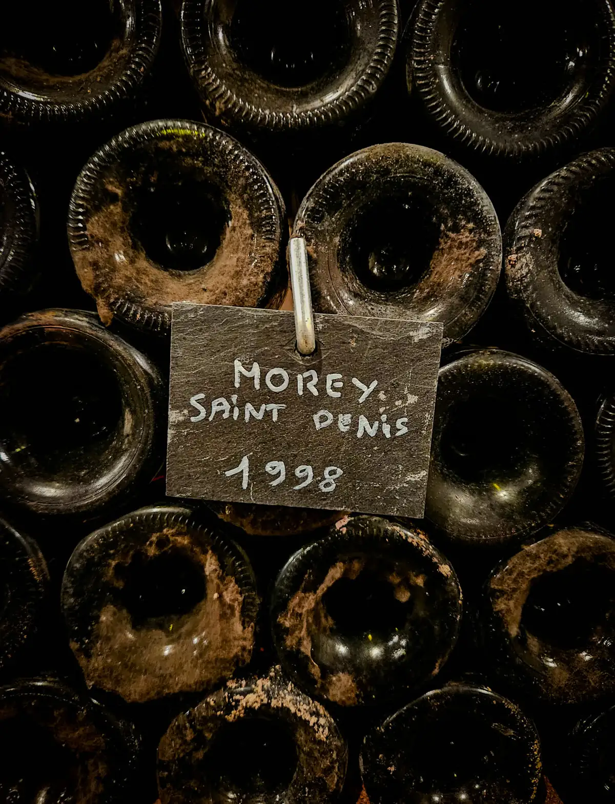 Old bottles of Morey-Saint-Denis 1998 under a slate label, in the family museum